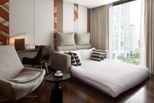 a living room filled with furniture and a window at Novotel Bangkok Sukhumvit 20 - SHA Extra Plus Certified in Bangkok