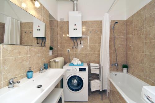 a bathroom with a washing machine and a washer at Apartments with 2 Bathrooms in Prague