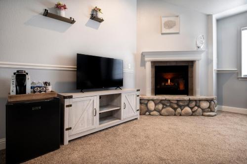 a living room with a tv and a fireplace at Hounds Tooth Inn in Oakhurst