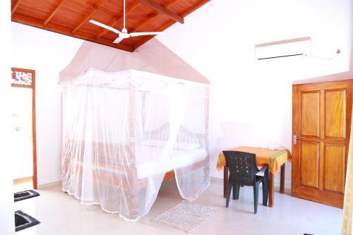 希卡杜瓦的住宿－THE KING APARTMENT，配有桌子和白色窗帘的房间