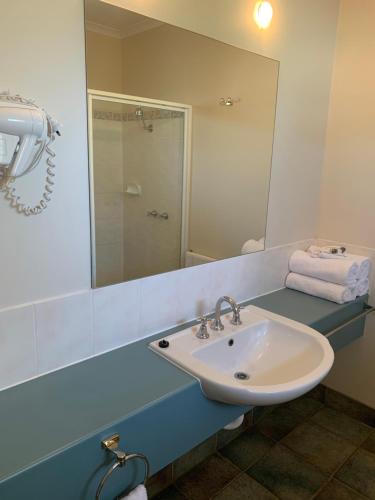 a bathroom with a sink and a mirror at Arthur Phillip Motor Inn in Cowes