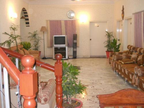 a large living room with couches and a television at Sunrise Guest House Multan in Multan