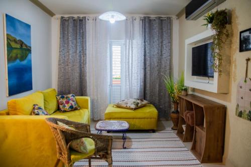 salon z żółtymi meblami i żółtą kanapą w obiekcie אצלנו - בגליל העליון w mieście Kirjat Szemona