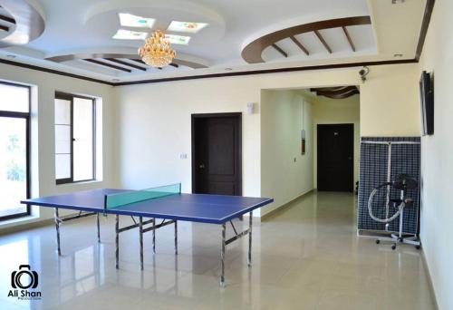 una mesa de ping pong en el medio de una habitación en The First Hotel, en Multán