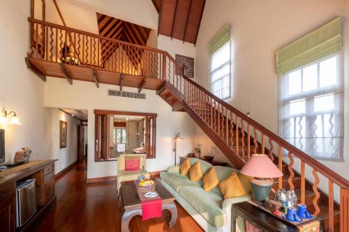 a living room with a staircase and a couch at Ariyasom Villa in Bangkok