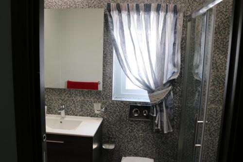 a bathroom with a sink and a shower with a window at Seaside Apartments in Marsaskala