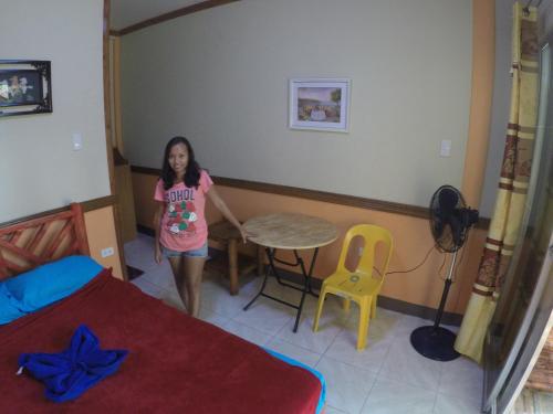 una niña en una habitación con una mesa y una silla en Mango House Apartments, en Panglao