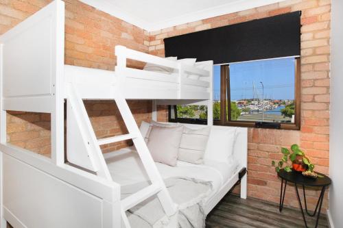 a white bunk bed in a room with a couch at Illawong Apartment 7 in Mooloolaba