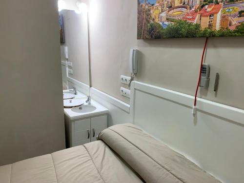 a small bathroom with a sink and a mirror at Apartments soho, Malaga center in Málaga