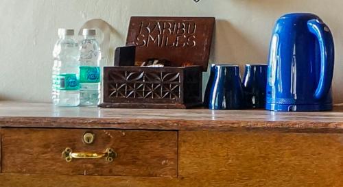 a wooden counter with bottles of water and a blue vase at Smiles Beach Hotel in Nungwi