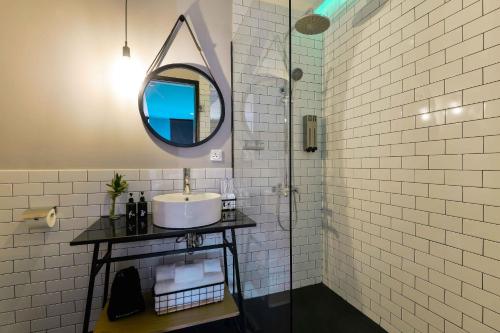 
a bathroom with a sink and a mirror at The Hammock Hotel Fine Arts Museum in Ho Chi Minh City
