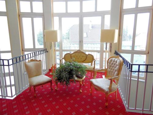 a room with two chairs and a table with a plant at Hotel Garni Arcis in Gomaringen