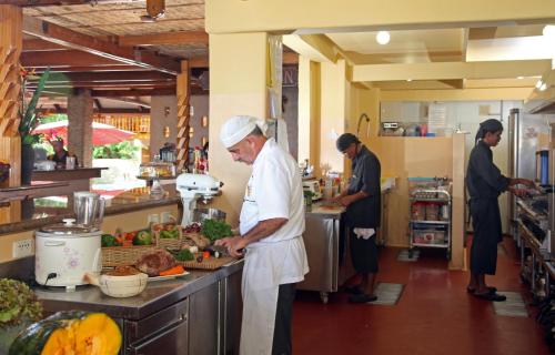 a man standing in a kitchen preparing food at El Galleon Beach Resort in Puerto Galera