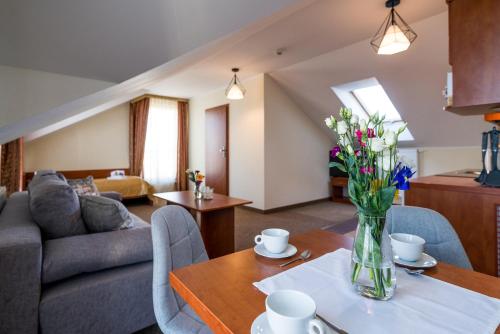 a living room with a vase of flowers on a table at Villa MARTII - Pokoje z Aneksami Kuchennymi in Władysławowo