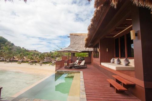 a resort with a swimming pool next to a beach at Cauayan Island Resort and Spa in El Nido