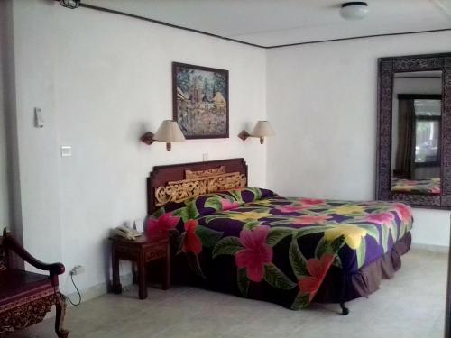 a bedroom with a bed with a colorful bedspread at Gazebo Beach Hotel in Sanur