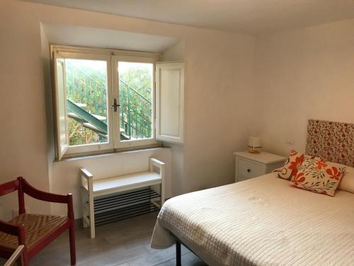 a bedroom with a bed and a window and a chair at Casa al mare 'Il Faro' in Quercianella