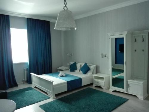 a bedroom with a bed with blue pillows and a mirror at Апартаменты на набережной 15 этаж in Astana