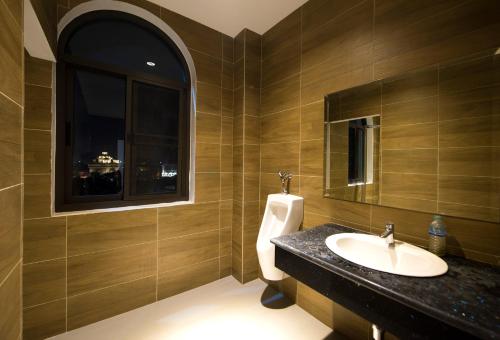 a bathroom with a sink and a urinal at Urbanite Hotel in Vientiane