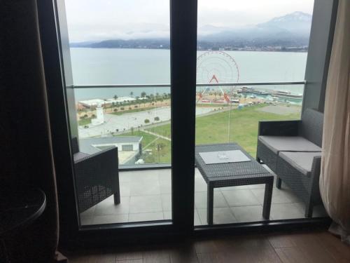 a balcony with a table and a view of the water at Premium apartment in Porta Batumi Tower in Batumi