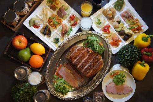 a table with a plate of meat and fruits and vegetables at Atami Hotel Paipuno Kemuri in Atami