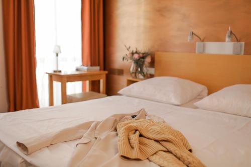 ein Hotelzimmer mit einem Bett mit einem Handtuch darauf in der Unterkunft Town Hotel Wiesbaden - kleines Privathotel in Bestlage in Wiesbaden