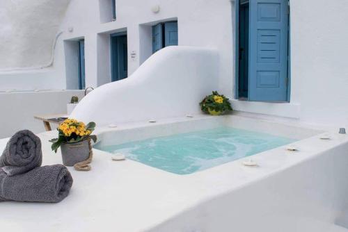 a swimming pool with a blue door and flowers at Stoa Cave Villas in Mesaria