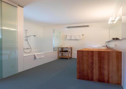 a bathroom with a shower and a wooden counter at Lechblick Appartement in Warth am Arlberg