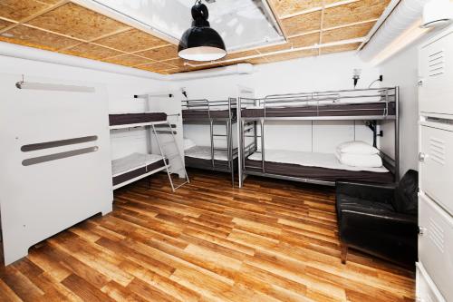 a room with three bunk beds and a wooden floor at City Backpackers Hostel in Stockholm