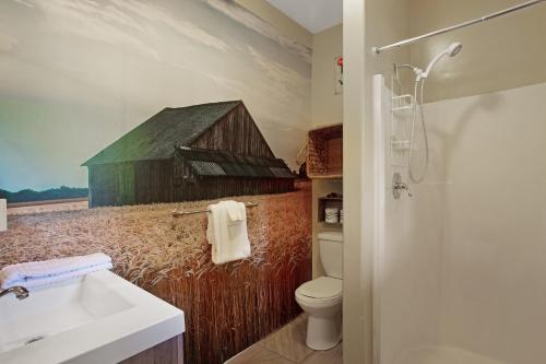 une salle de bains avec une peinture représentant une grange sur le mur. dans l'établissement Fort Bragg Farmhouse, à Fort Bragg