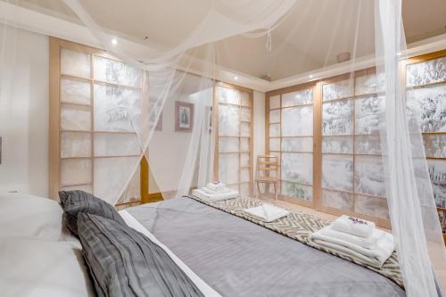 a bedroom with a bed with a canopy and windows at VENETO COMFORTABLE Apartment in Rome