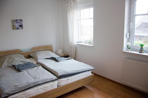 - une chambre avec un lit et 2 fenêtres dans l'établissement Ferienhaus Paula, à Hooksiel