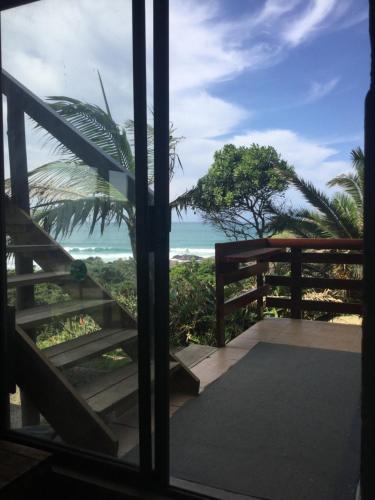 a view of the ocean from the balcony of a house at CORAM DEO SaltyWaves double en-suite rooms with sea views in Coffee Bay