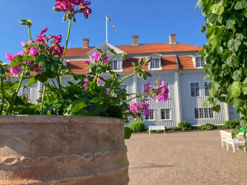 a large white house with flowers in front of it at Tofta Herrgård in Lycke