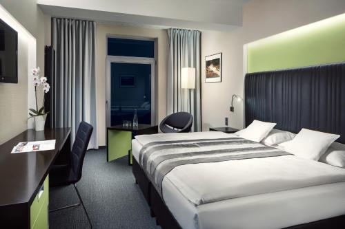ein Hotelzimmer mit einem Bett und einem Schreibtisch in der Unterkunft Sport & Relax Hotel Davidek in Trutnov