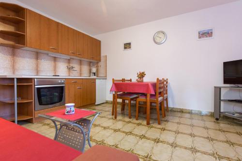 a kitchen with a table and chairs and a red table at Neda in Punat