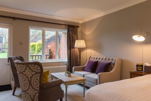 a hotel room with a bed and a couch and a table at Burley Manor in Burley