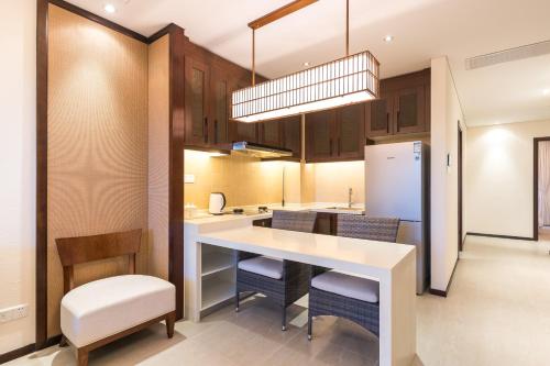 a kitchen with a table and chairs and a refrigerator at Iccssi Villa Haitang Bay Sanya in Sanya