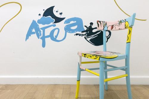 une chaise bleue devant un mur avec le mot africa dans l'établissement Afea Art & Rooms, à Palerme