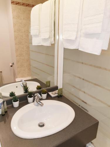 une salle de bain avec un lavabo blanc et un miroir dans l'établissement Neoresid - Résidence Clos Morlot, à Dijon