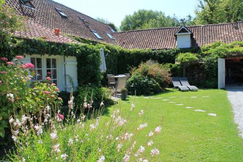 um jardim de uma casa com flores e plantas em Chambre du Rouard LE RUISSEAU em Camiers