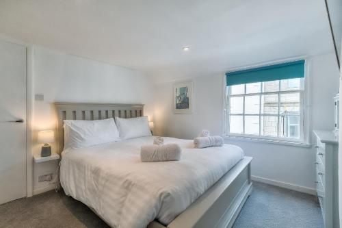 a bedroom with a large white bed with two pillows at Shell Seekers in St Ives
