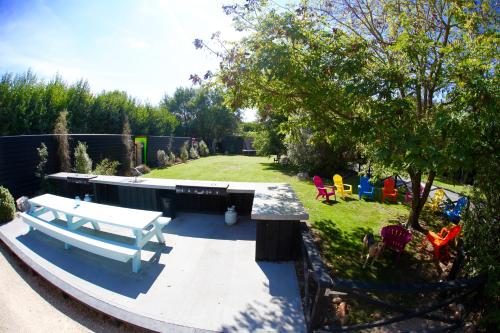 a backyard with a picnic table and chairs in the grass at Adventure Inn Marahau in Marahau