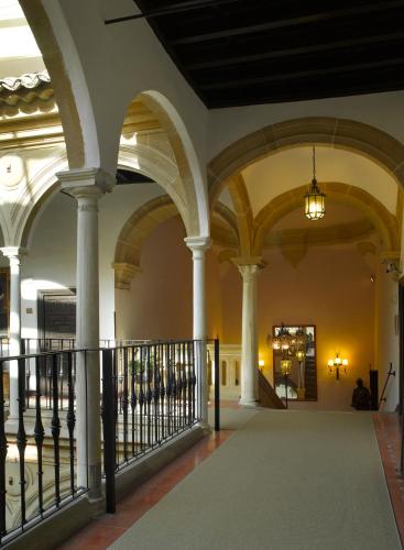 a hallway of a building with columns and ceilings at Parador de Ubeda in Úbeda