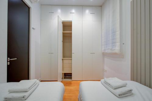 2 łóżka w pokoju z białymi ścianami w obiekcie Luxury Rooms Madrid Center w Madrycie