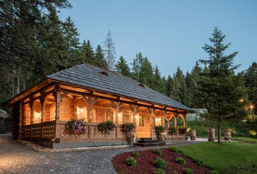 a wooden pavilion in a garden at dusk at Teleferic Grand Hotel in Poiana Brasov