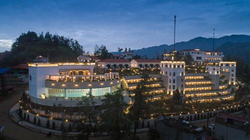 a large building with lights on it at night at Silk Path Grand Sapa Resort & Spa in Sa Pa