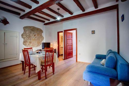 Ul. Ivana Farolfija 12 Apartman Domina في فيس: غرفة معيشة مع طاولة وأريكة زرقاء