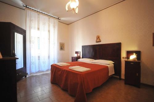 a bedroom with a large bed with a red blanket at albergo Fiorentino in Sansepolcro