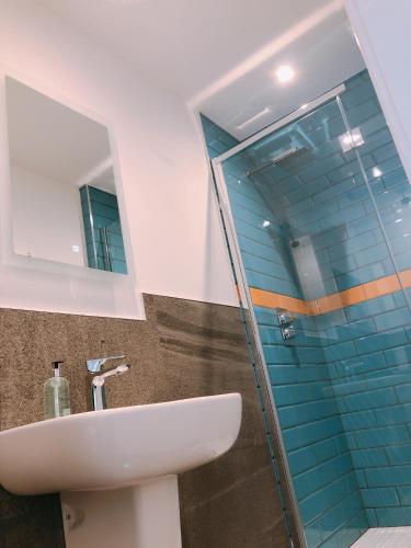 a bathroom with a sink and a glass shower at Ravenscraig Guest House in Aviemore